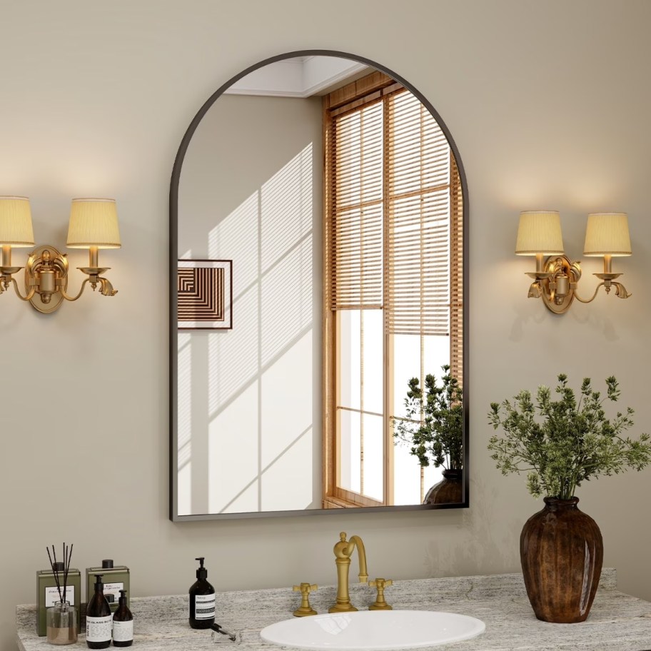 an arched black frame mirror over a mantle