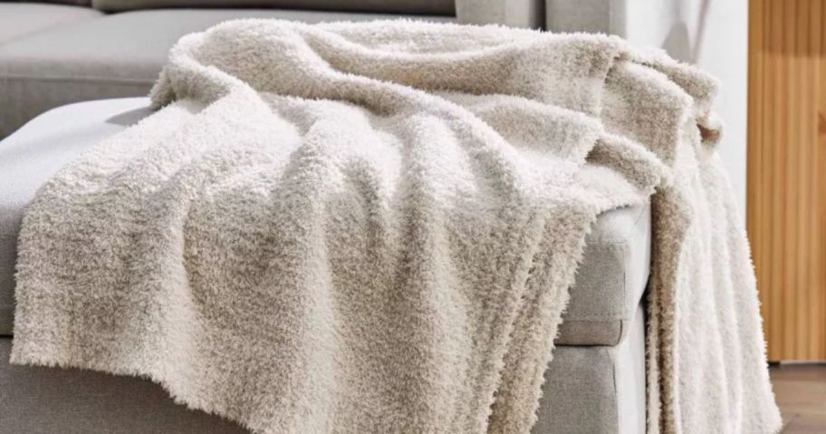 A chaise with a white blanket on it 