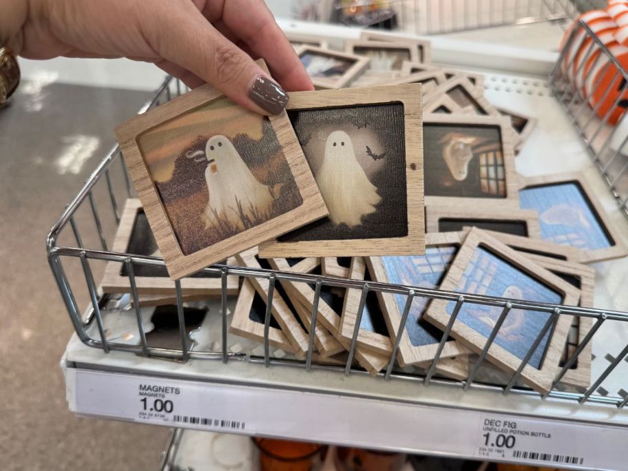 A hand holding small pictures of ghosts with a frame