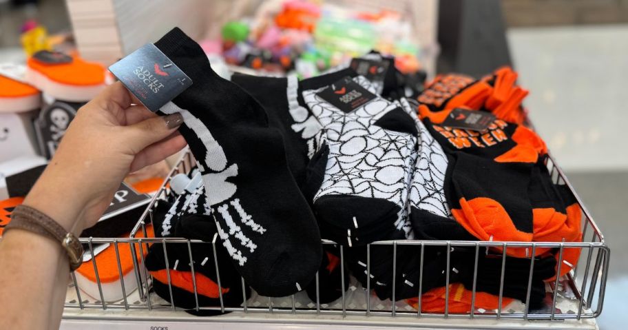 a hand holding Halloween themed socks