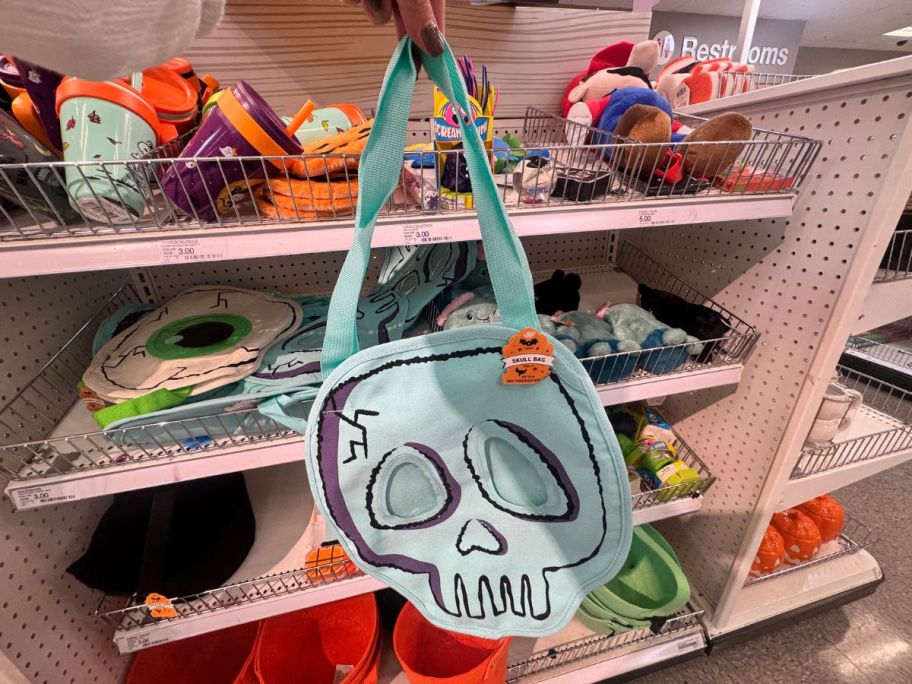 A person holding a skull bag