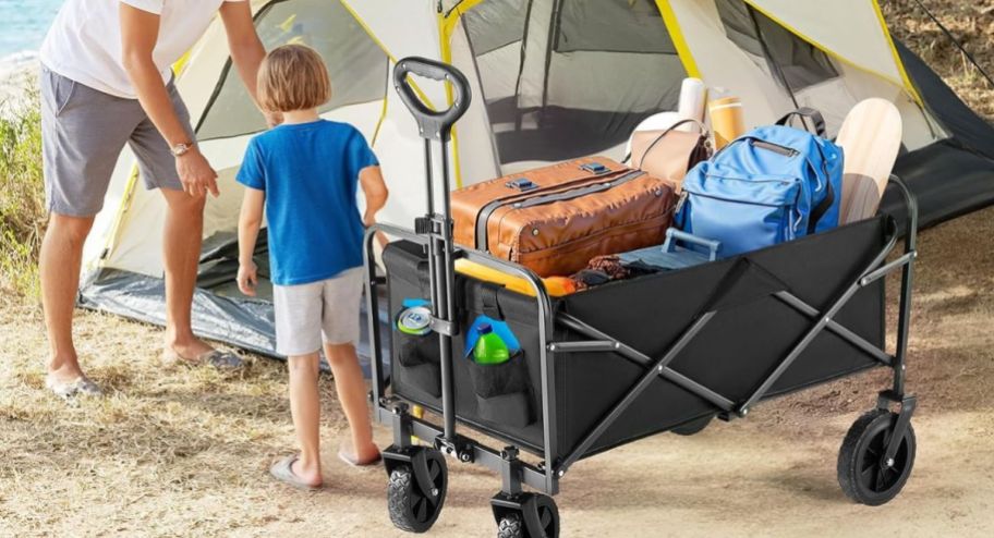 rolling cart with items inside and a childing standing next to it at the beach