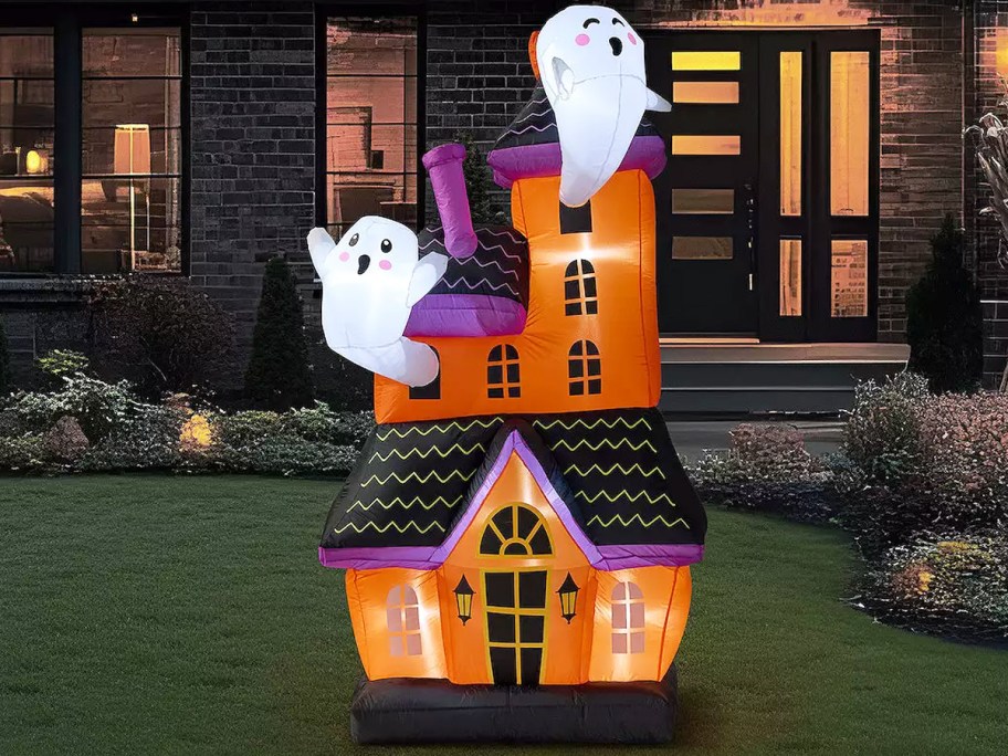 inflatable of a haunted house with ghosts coming out from windows