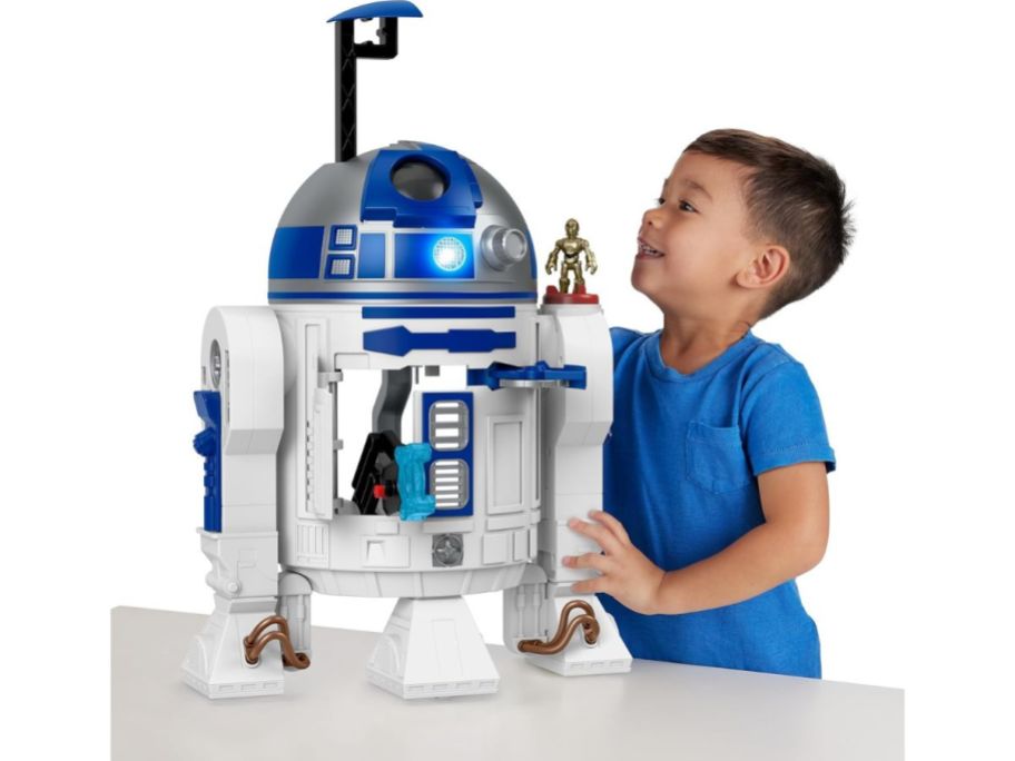 A boy playing with a large R2 D@ toy
