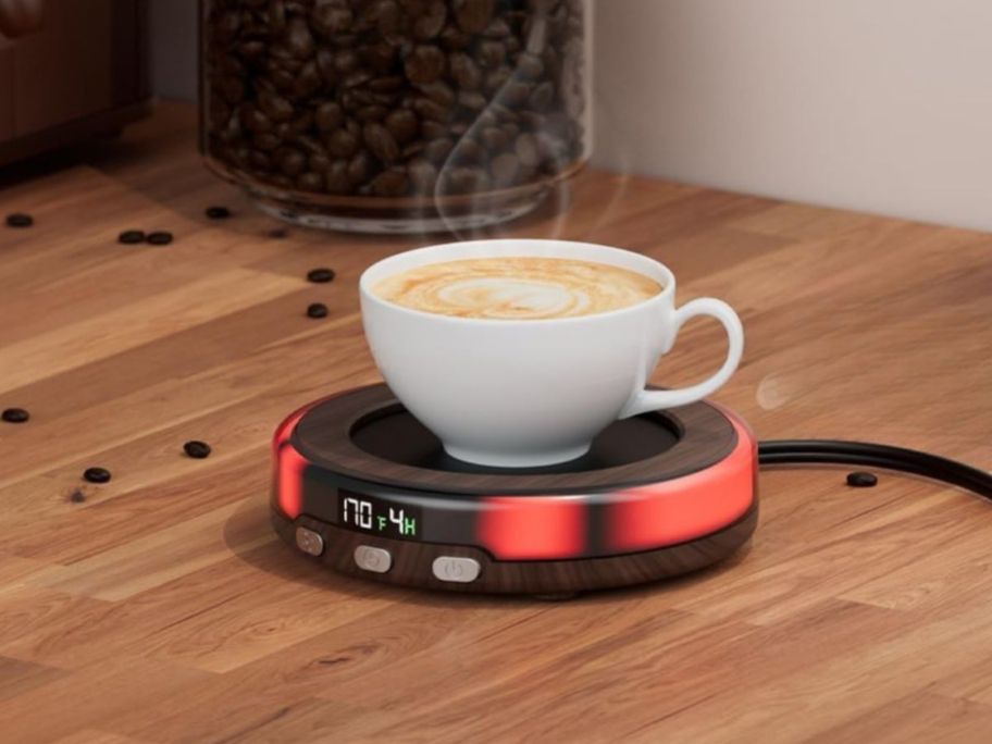 A latte in a small coffee cup on top of a circular warmer