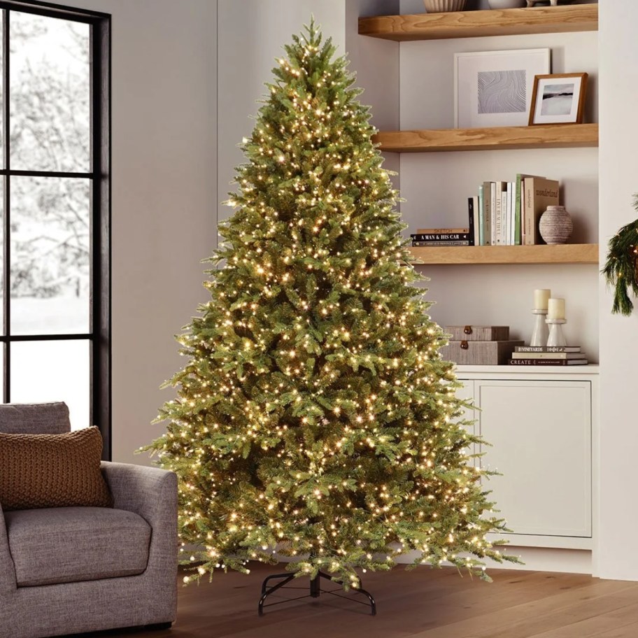 a pre-lit Christmas tree in a living room