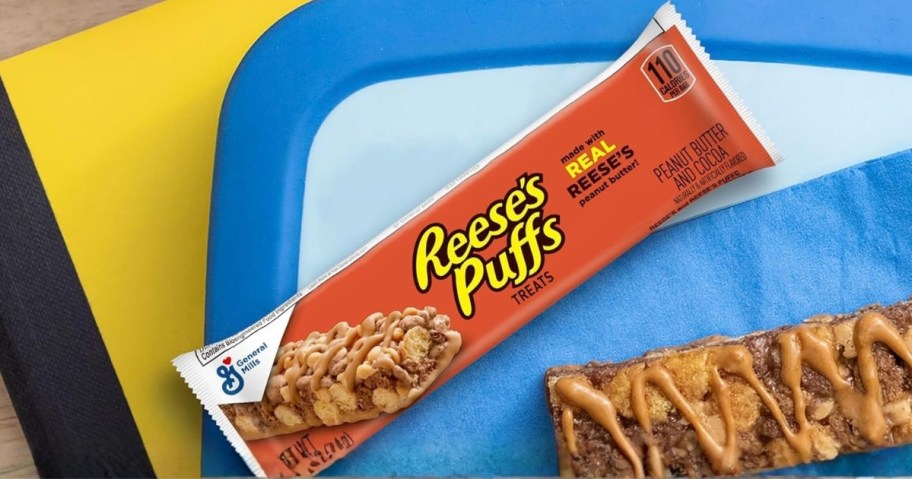 a Reese's puffs cereal bar in the wraper and one out of the wrapper on school folders