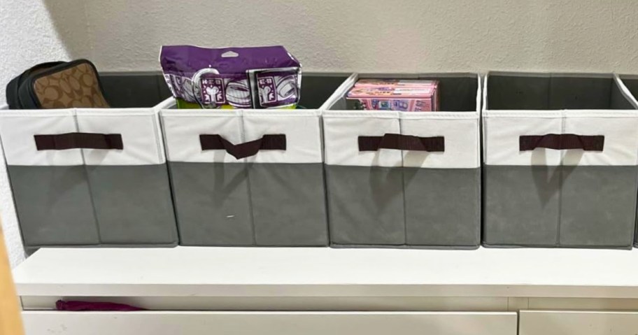 four grey and white fabric bins in a closet