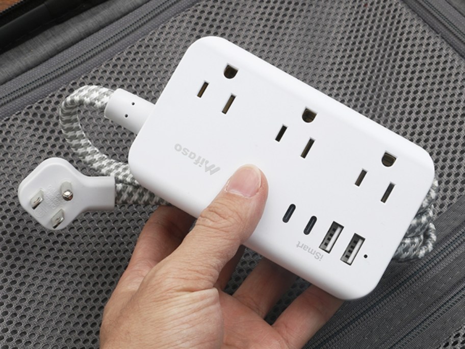 hand holding a small power strip and charging station