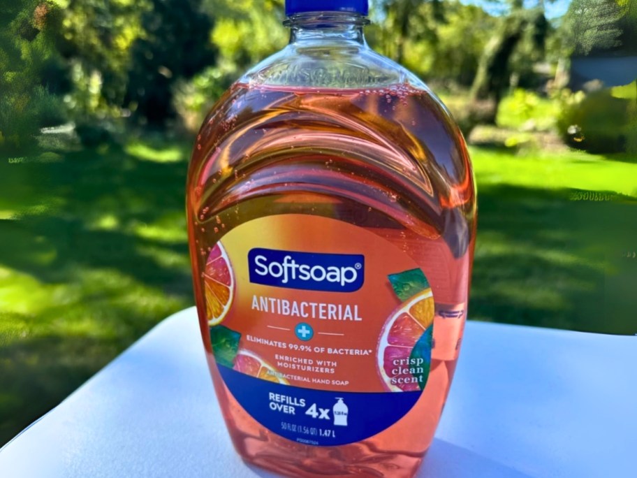 a Softsoap hand soap refill bottle sitting on a table outside