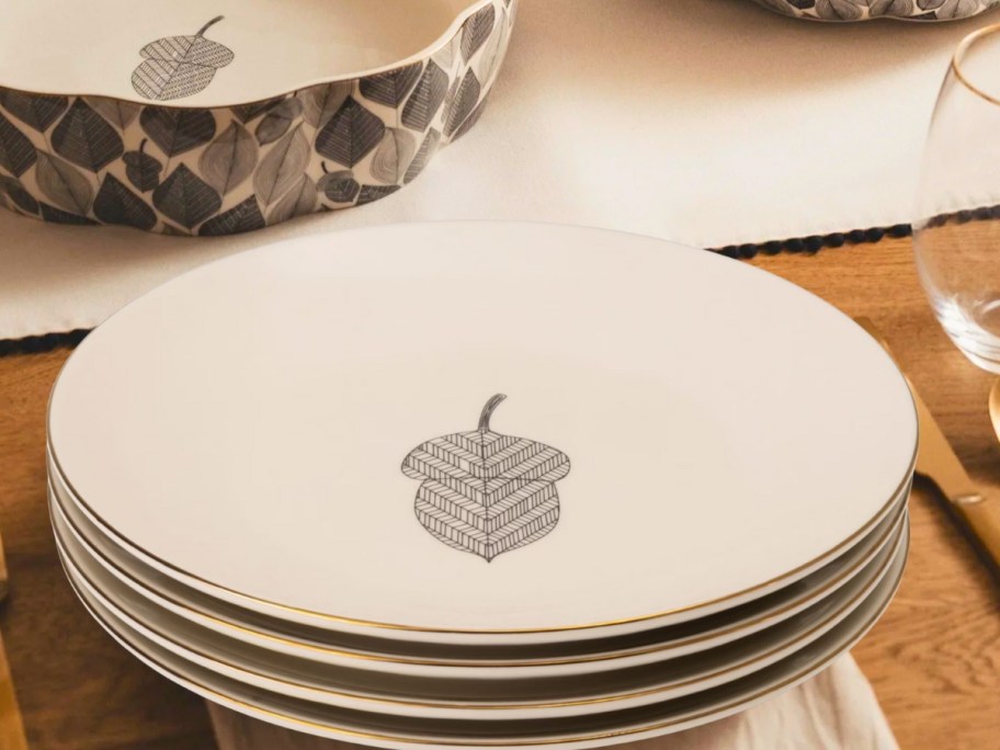 a set of dinnerware plates with a single a acorn pattern on a table