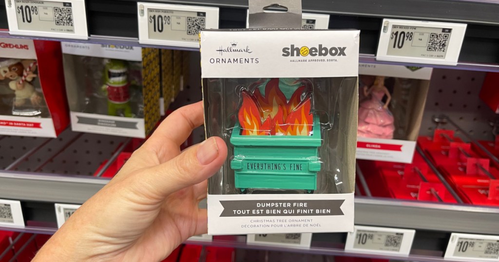 Woman holding Hallmark Dumpster fire ornament in store