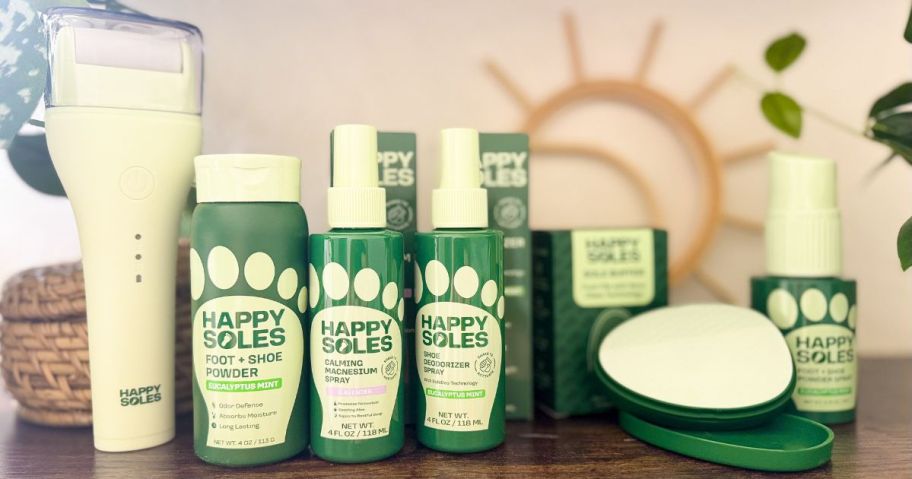 A lineup of Happy Soles foot care products including an electric callus remover, foot powders, sprays, and a glass foot file. 