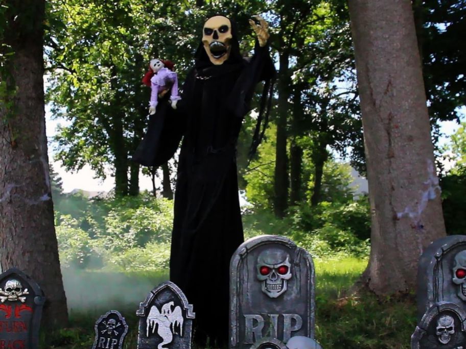a creepy skeleton in a black cloak in a graveyard