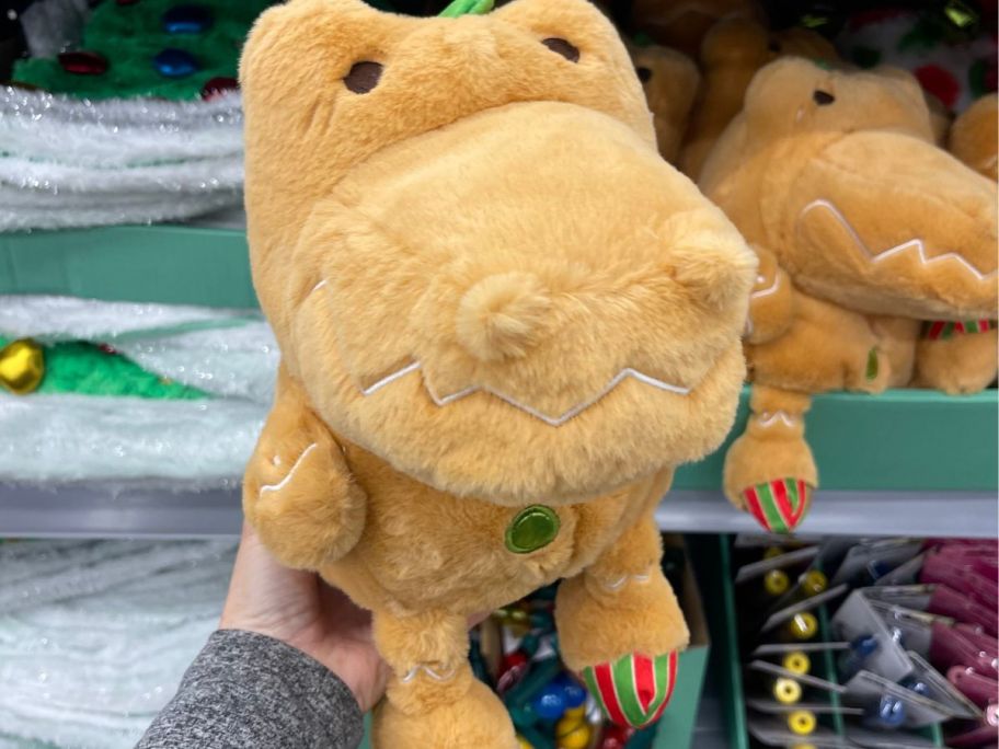 hand holding Holiday Time Gingerbread-Scented Cozy Cookie Dinosaur Christmas Plush