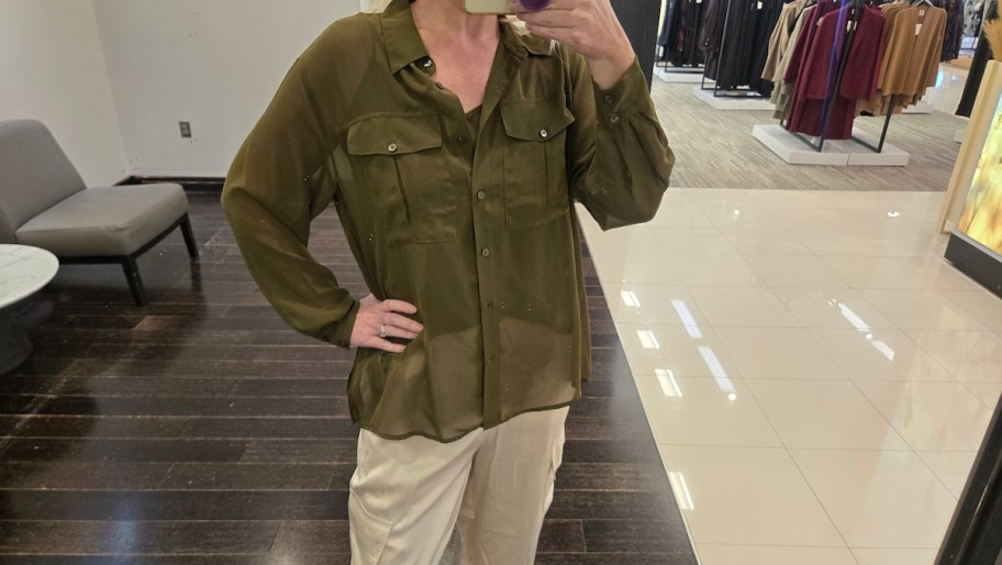 woman taking selfie wearing green blouse