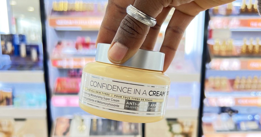 hand holding up a jar of IT Cosmetics Confidence in a Cream