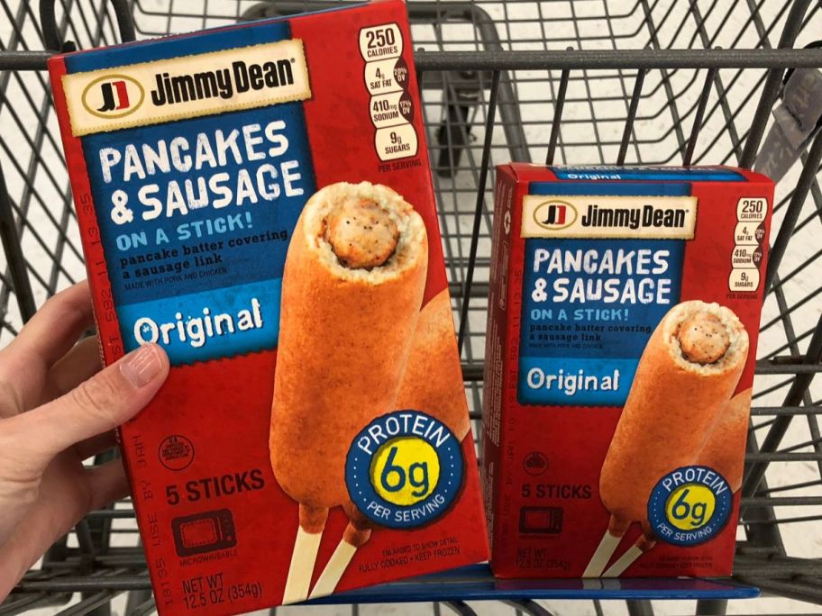 Hand holding a box of Jimmy Dean Pancakes & Sausage on a Stick