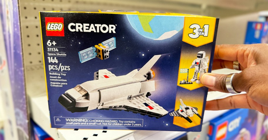 hand grabbing LEGO Creator 3-in-1 Space Shuttle box from shelf