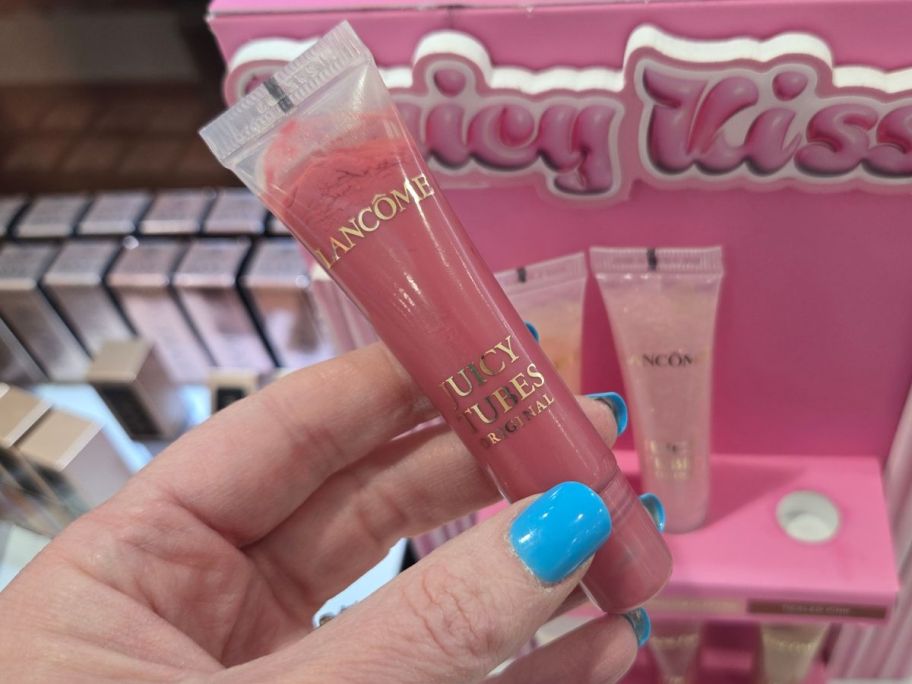 Hand holding a pink Lancome Juicy Tubes Lip Gloss