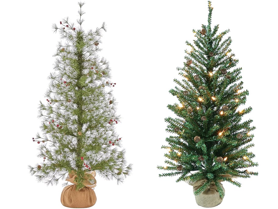 two small christmas trees with berries and pinecones