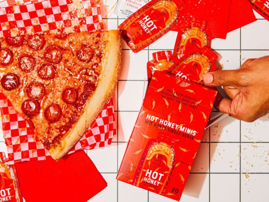 A box of Nate's Hot Honey Singles next to a pepperoni pizza