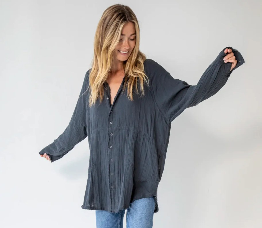 woman dancing in oversized blue button down shirt