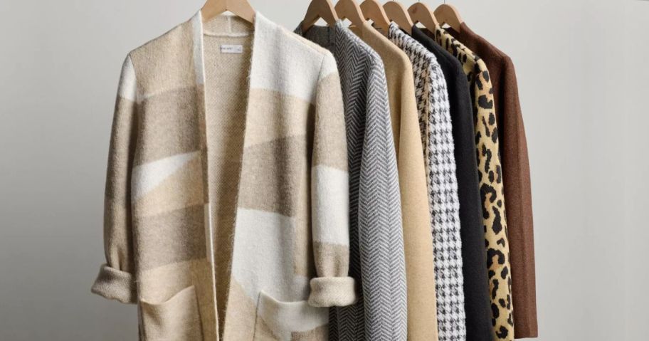 Several Nine West Coatigan Sweaters on wooden hangers