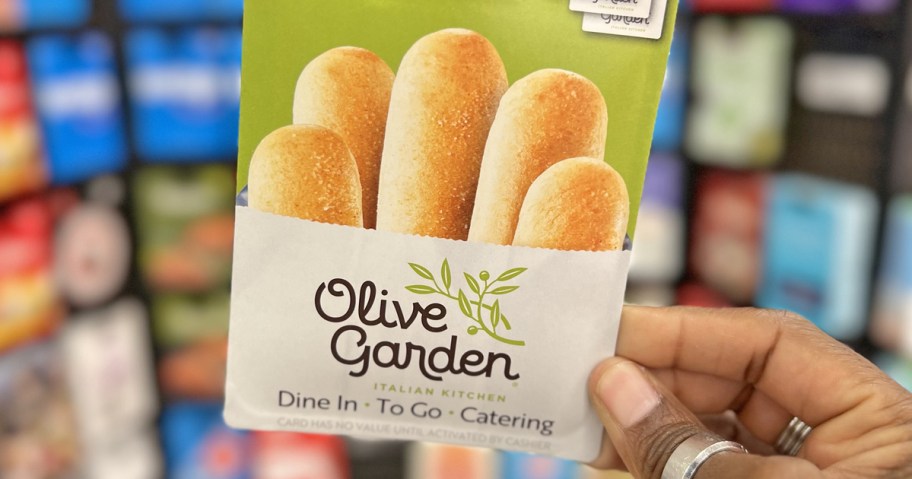 hold holding up an Olive Garden gift card