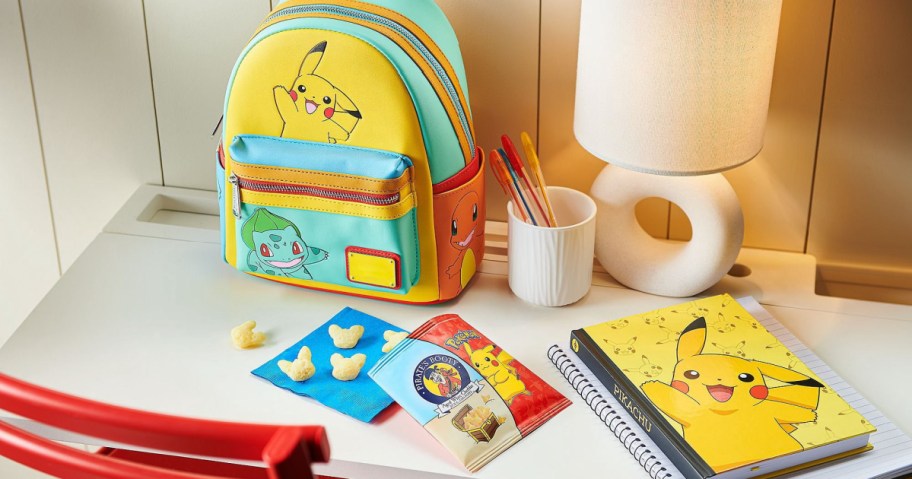 Pok&eacute;mon Pirate's Booty snacks on a blue napkin on top of a desk next to Pok&eacute;mon books and a backpack