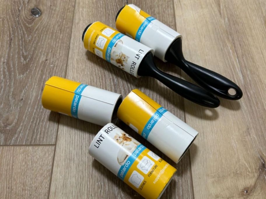 5 lint rollers on a wooden floor