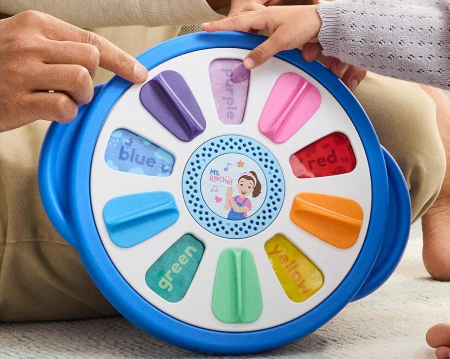 a baby and parent playing with a interactive toy