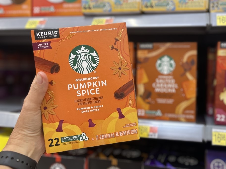 person holding box of starbucks pumpkin spice k-cups in store