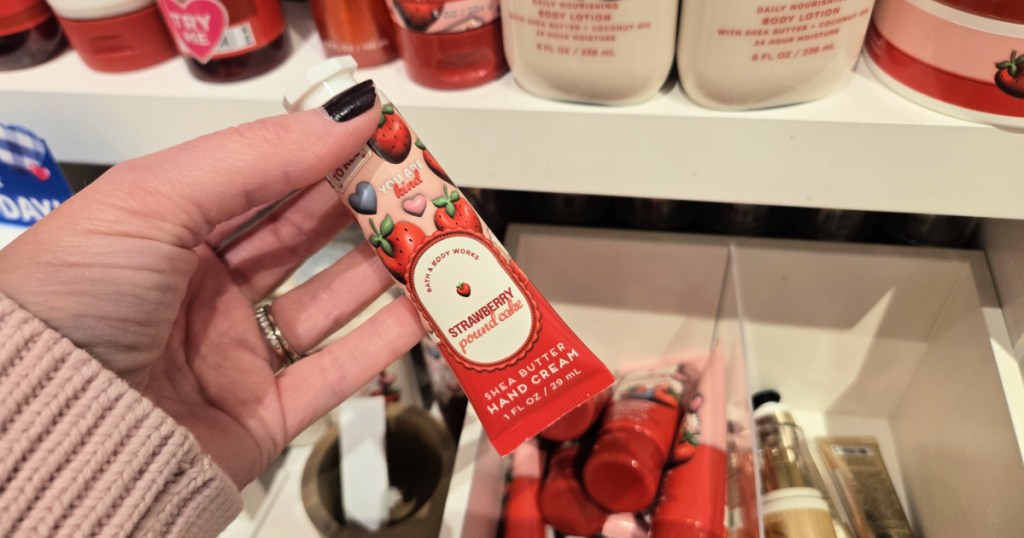 woman grabbing tube of Strawberry Pound Cake Hand Cream
