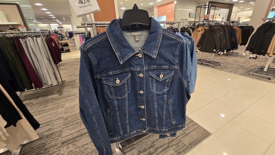 denim jacket hanging on hanger in store