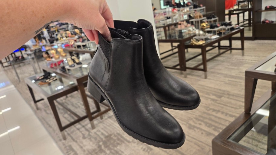 hand holding a pair of black lug boots in shoe store