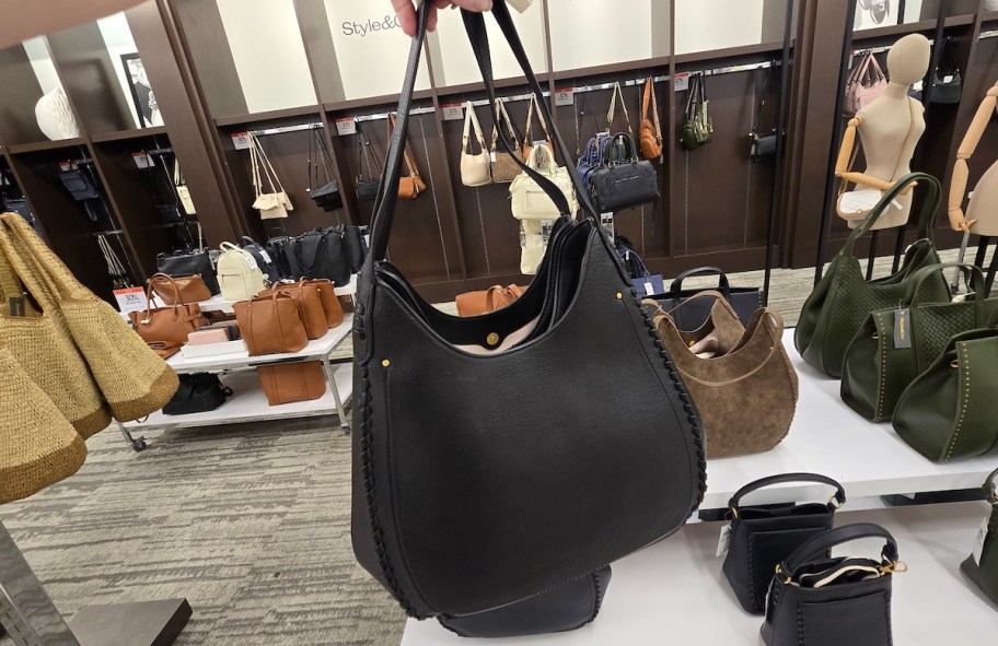 hand holding up black purse in store