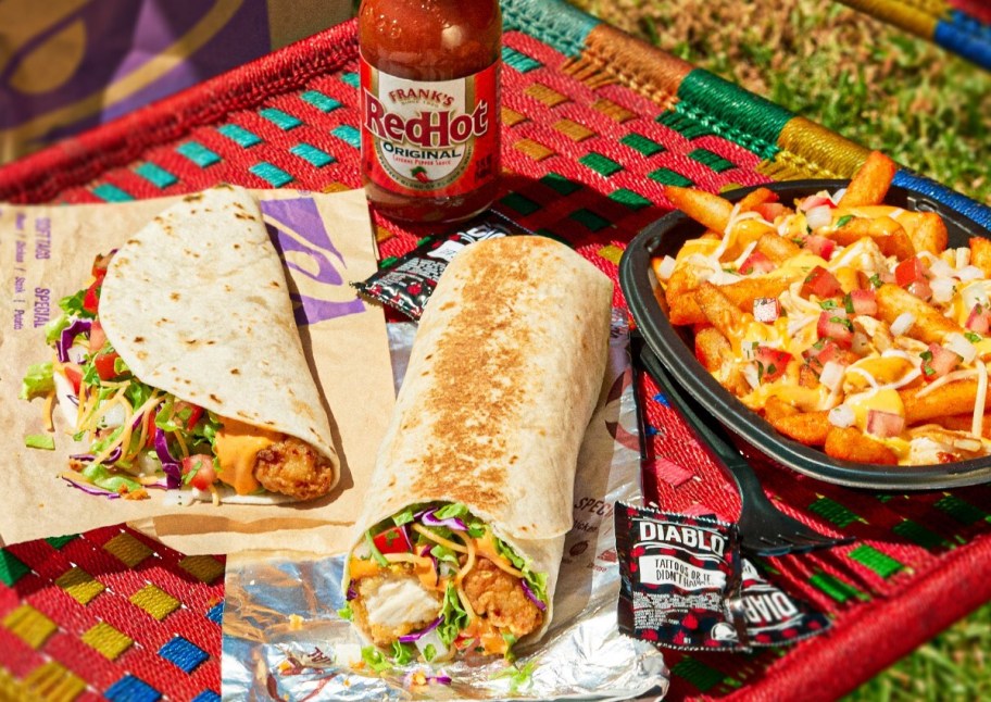 taco, burrito, and fries next to bottle of Frank's Red Hot sauce