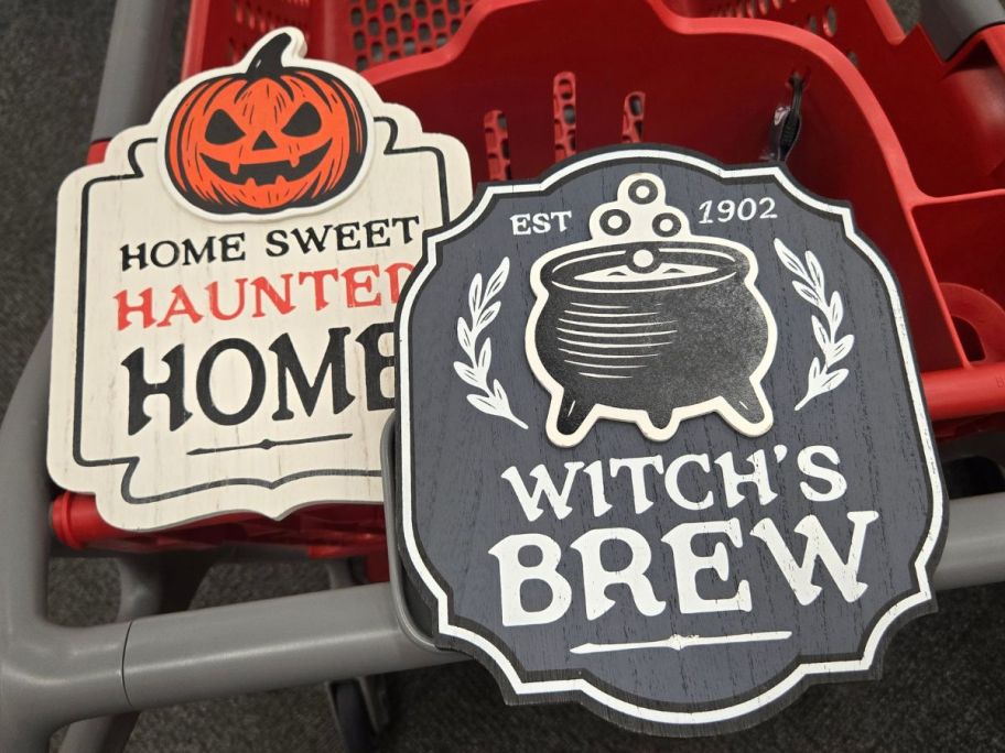 Two Wooden halloween signs on a Target shopping cart