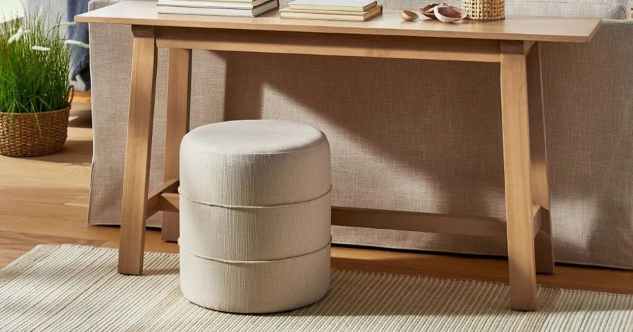 An ottoman under a table in a living room 