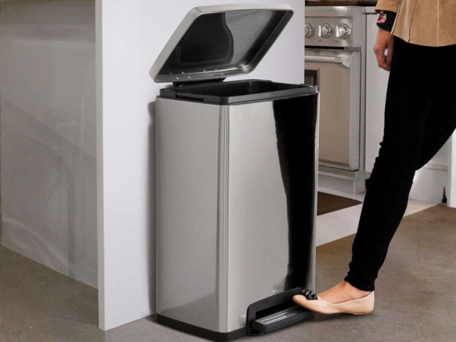 woman opening Tramontina 13-Gallon Step Trash Can in kitchen