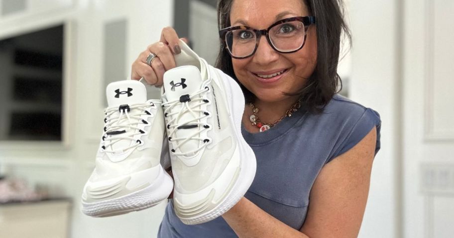 Woman holding a pair of Under Armour shoes