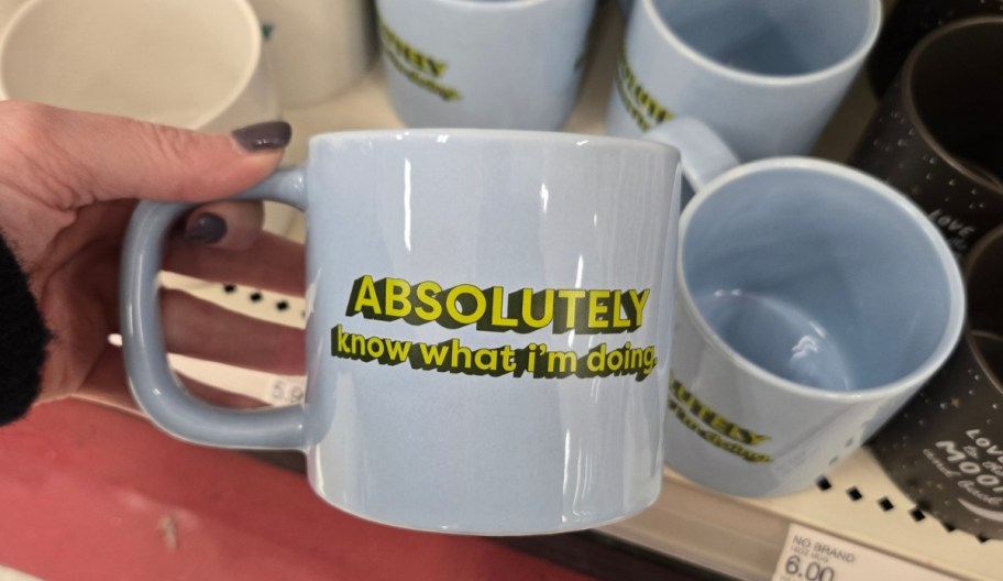 a womans hand holding a coffee mug