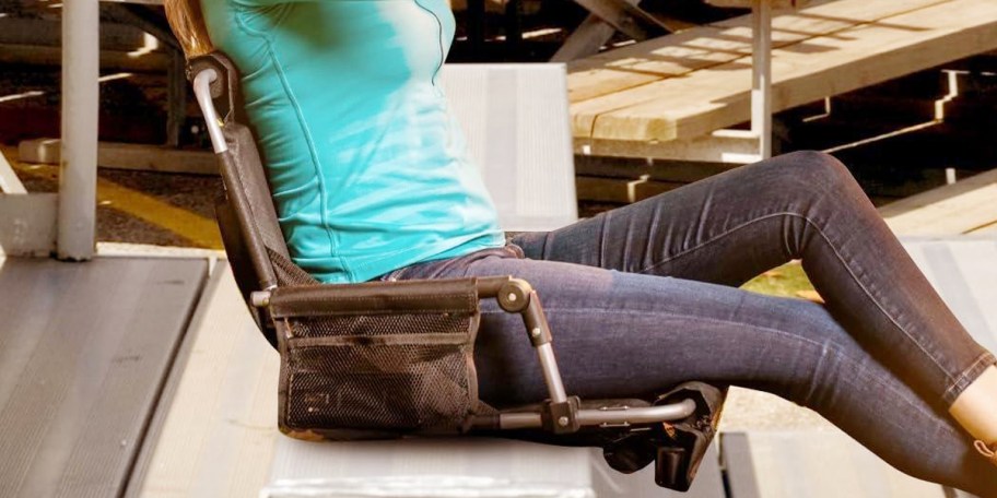 woman sitting in black stadium seat 