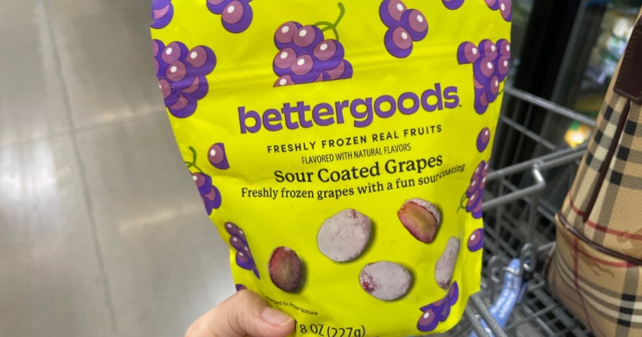 hand holding a bag of bettergoods sour-coated grapes candy