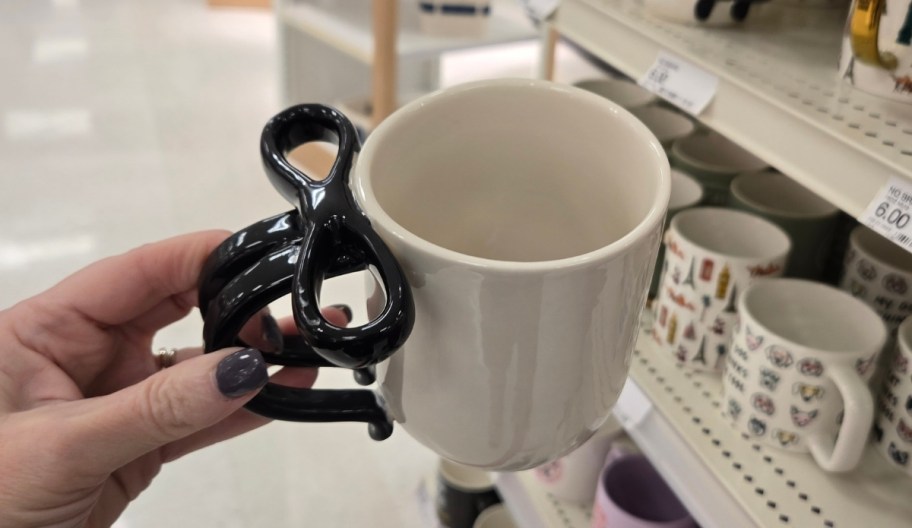 a womans hand holding a coffee mug