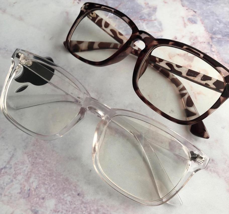 Clear and tortoise, colored blue light blocking glasses on countertop 