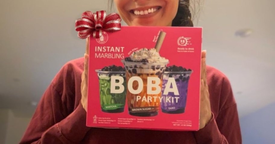 girl holding boba kit box with holiday bow on corner