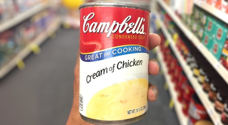 a mans hand holding a can of cream of chicken soup