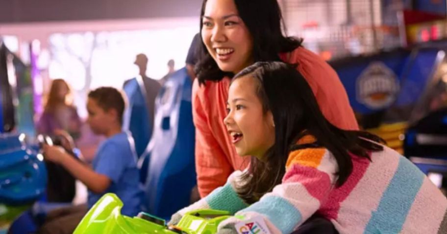 a woman and child playing games at chuck e cheese